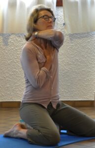 Assis sur un banc, agrandir la cage thoracique pour étirer les ligaments péricardiques. Respiration Yoga Yvette Clouet.